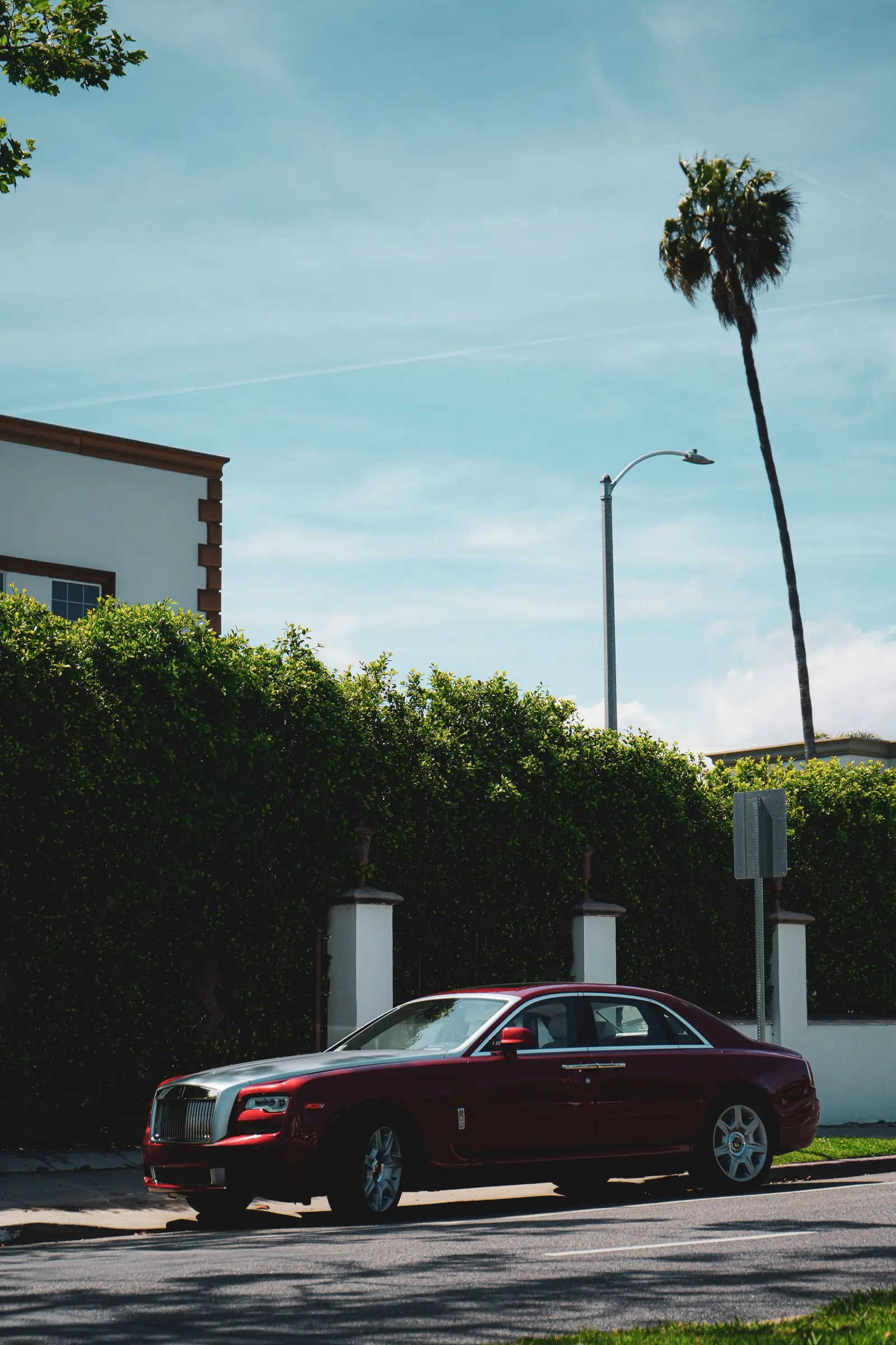 Rolls-Royce Ghost granate aparcado junto a un seto
